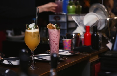 Photo of Glasses with different cocktails on bar counter