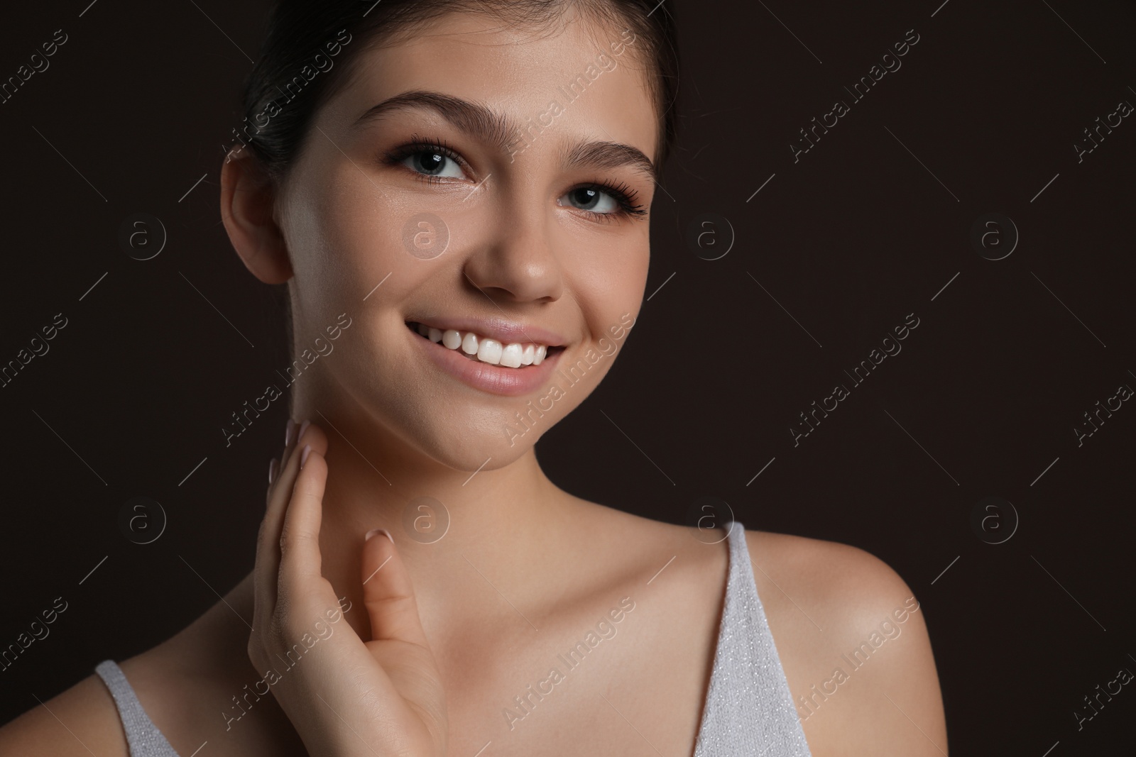 Photo of Pretty girl on brown background. Beautiful face with perfect smooth skin