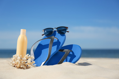 Photo of Stylish beach accessories for summer vacation on sand near sea