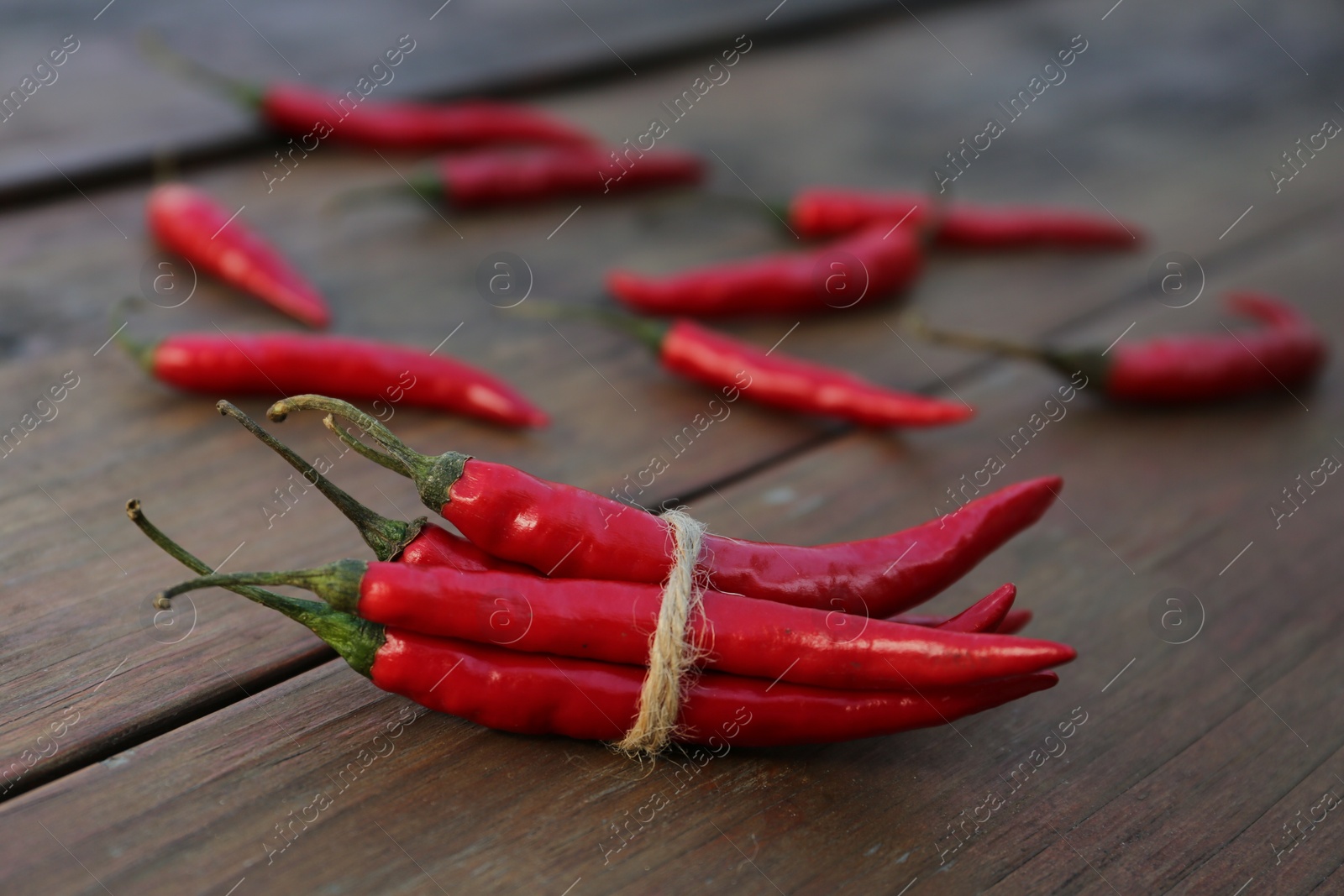 Photo of Fresh ripe chili peppers on wooden table