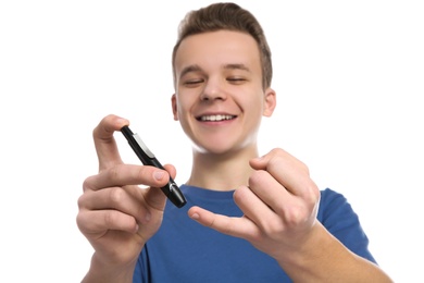 Photo of Teen boy using lancet pen on white background. Diabetes control