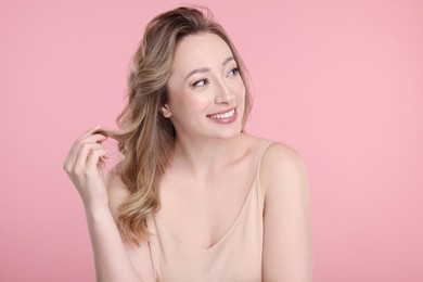 Portrait of smiling woman on pink background