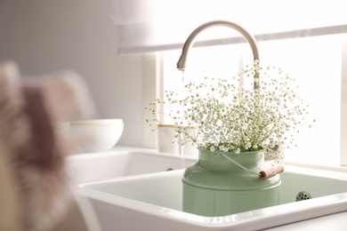 Photo of Bouquet of gypsophila flowers in sink, space for text. Kitchen interior design