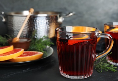 Tasty mulled wine and fresh ingredients on black table