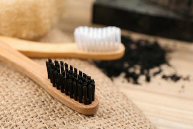 Natural bamboo toothbrush with charcoal bristle on table, closeup