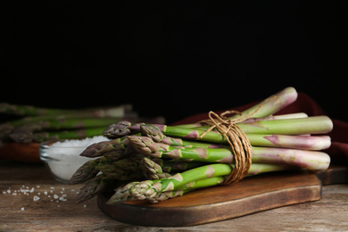 Photo of Fresh raw asparagus on wooden table, closeup