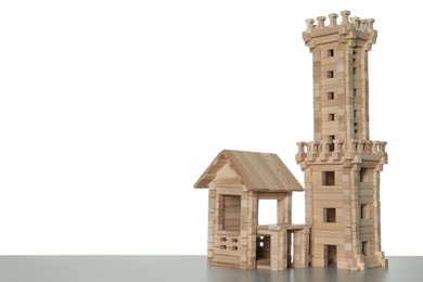 Wooden tower and building on light grey table against white background, space for text. Children's toy