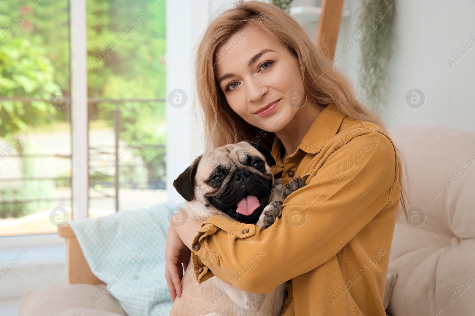 Photo of Woman with cute pug dog at home. Animal adoption