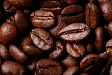 Photo of Aromatic roasted coffee beans as background, top view