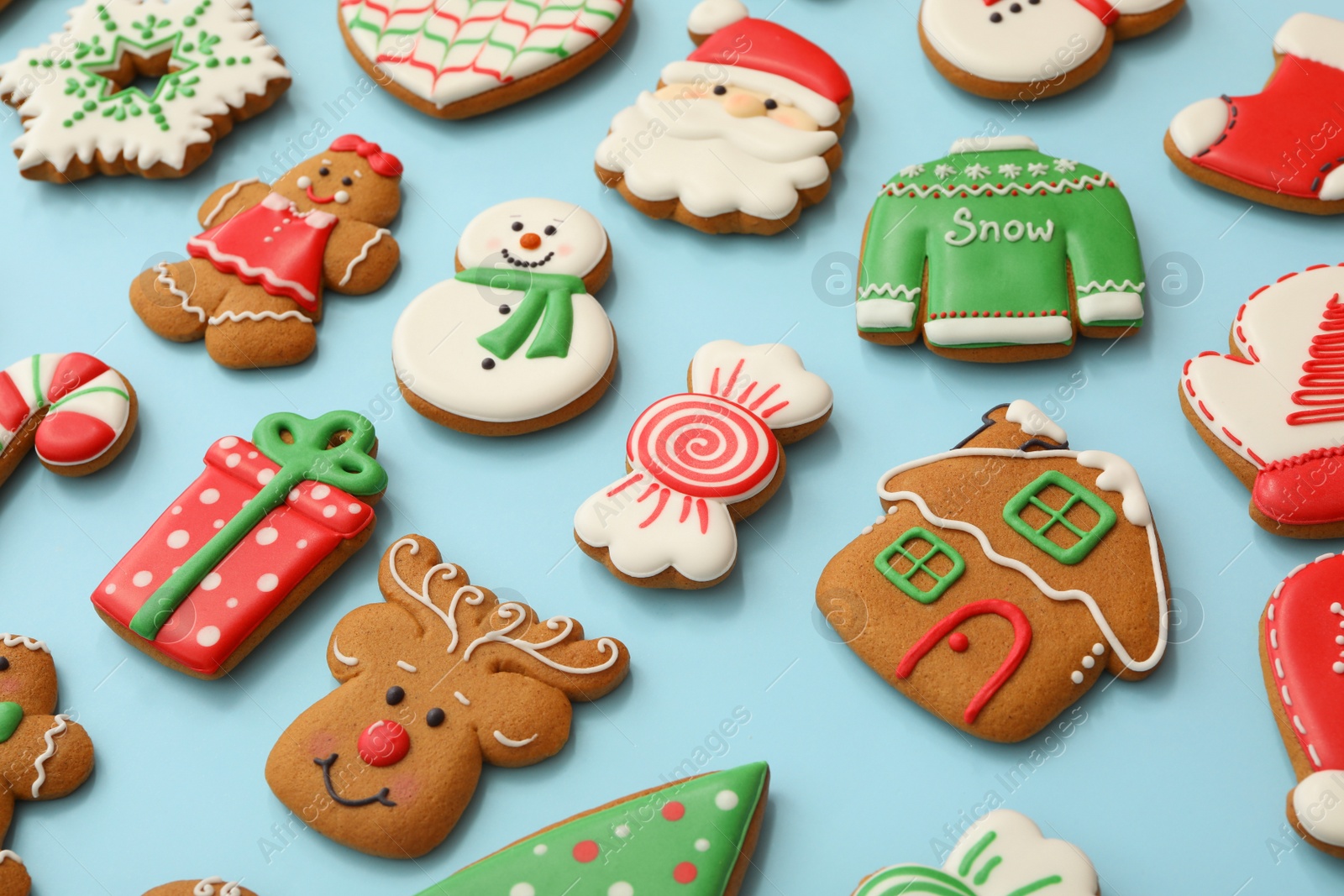 Photo of Different Christmas gingerbread cookies on light blue background, closeup