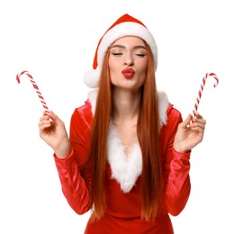 Photo of Young woman in red dress and Santa hat with candy canes on white background. Christmas celebration