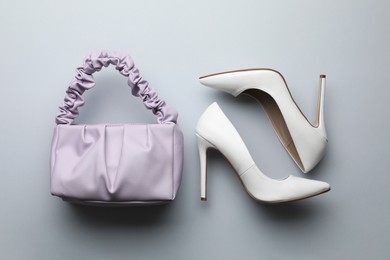 Photo of Stylish woman's bag and shoes on light background, flat lay