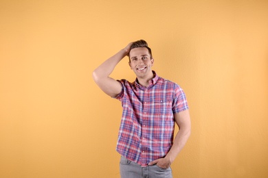 Photo of Handsome young man smiling on color background