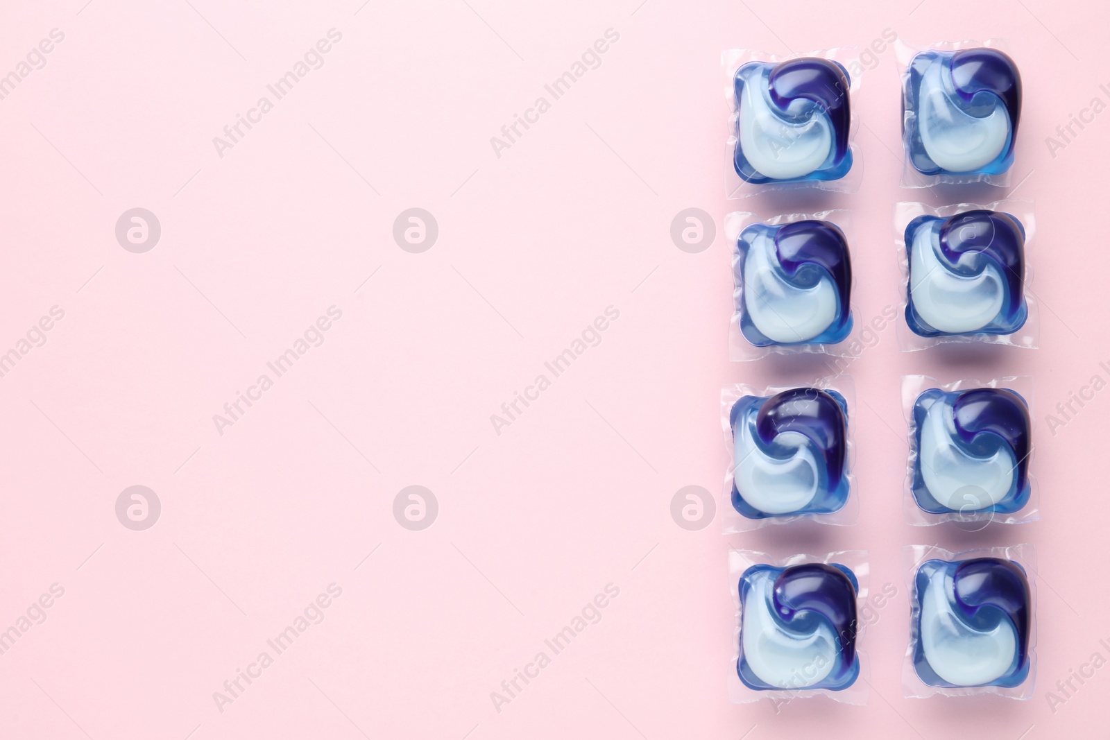 Photo of Laundry capsules on pink background, flat lay. Space for text