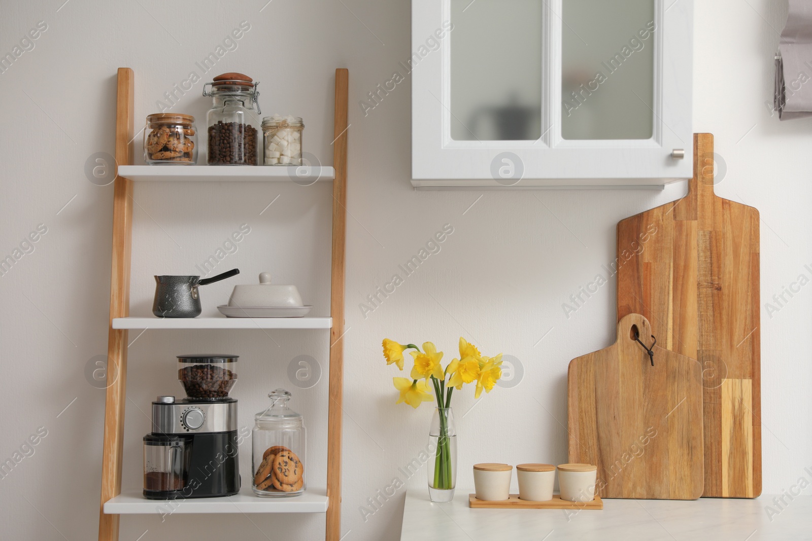 Photo of Modern coffee grinder on shelving unit in kitchen