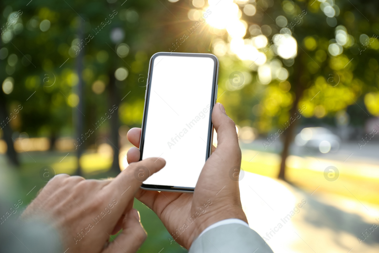 Photo of Man using modern mobile phone in park, closeup