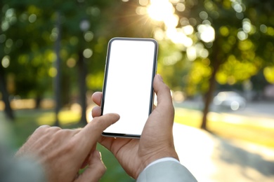 Man using modern mobile phone in park, closeup