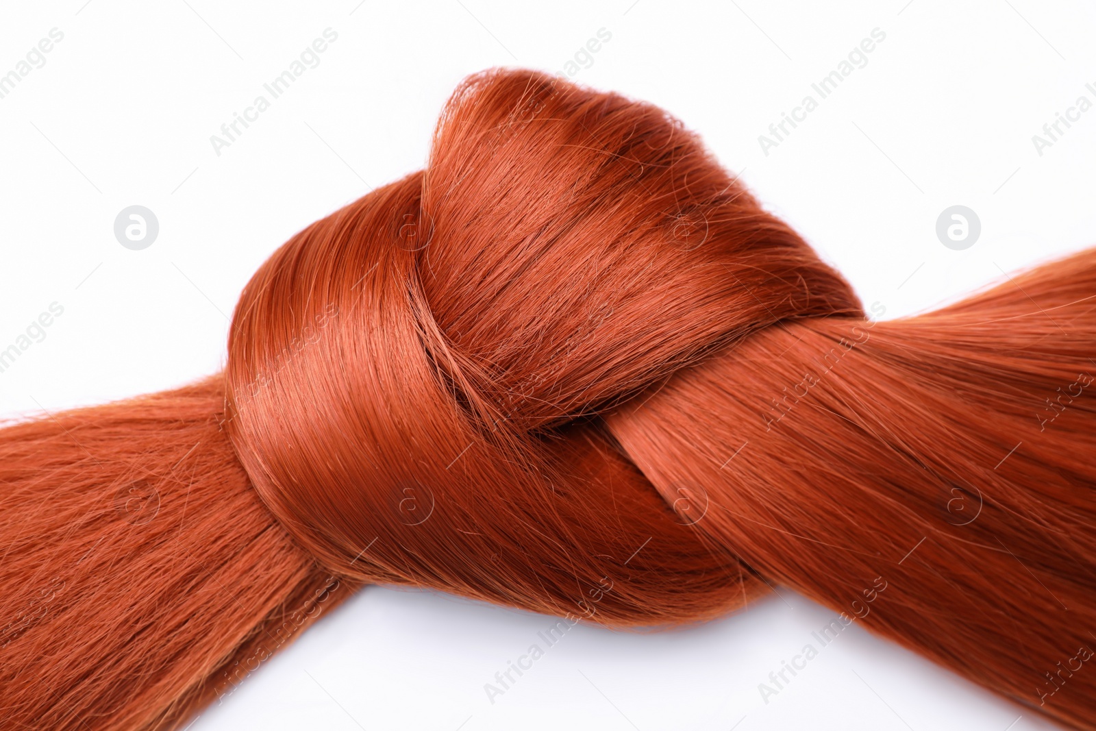 Photo of Beautiful strand of red hair tied in knot on white background, top view