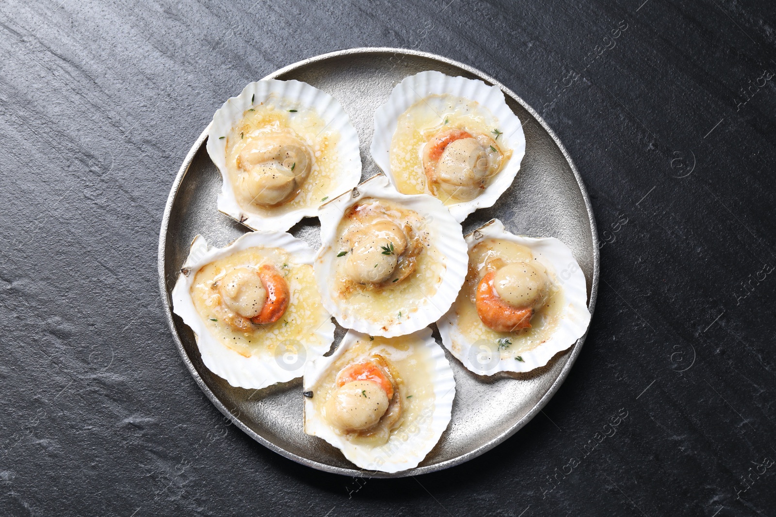 Photo of Fried scallops in shells on black table, top view