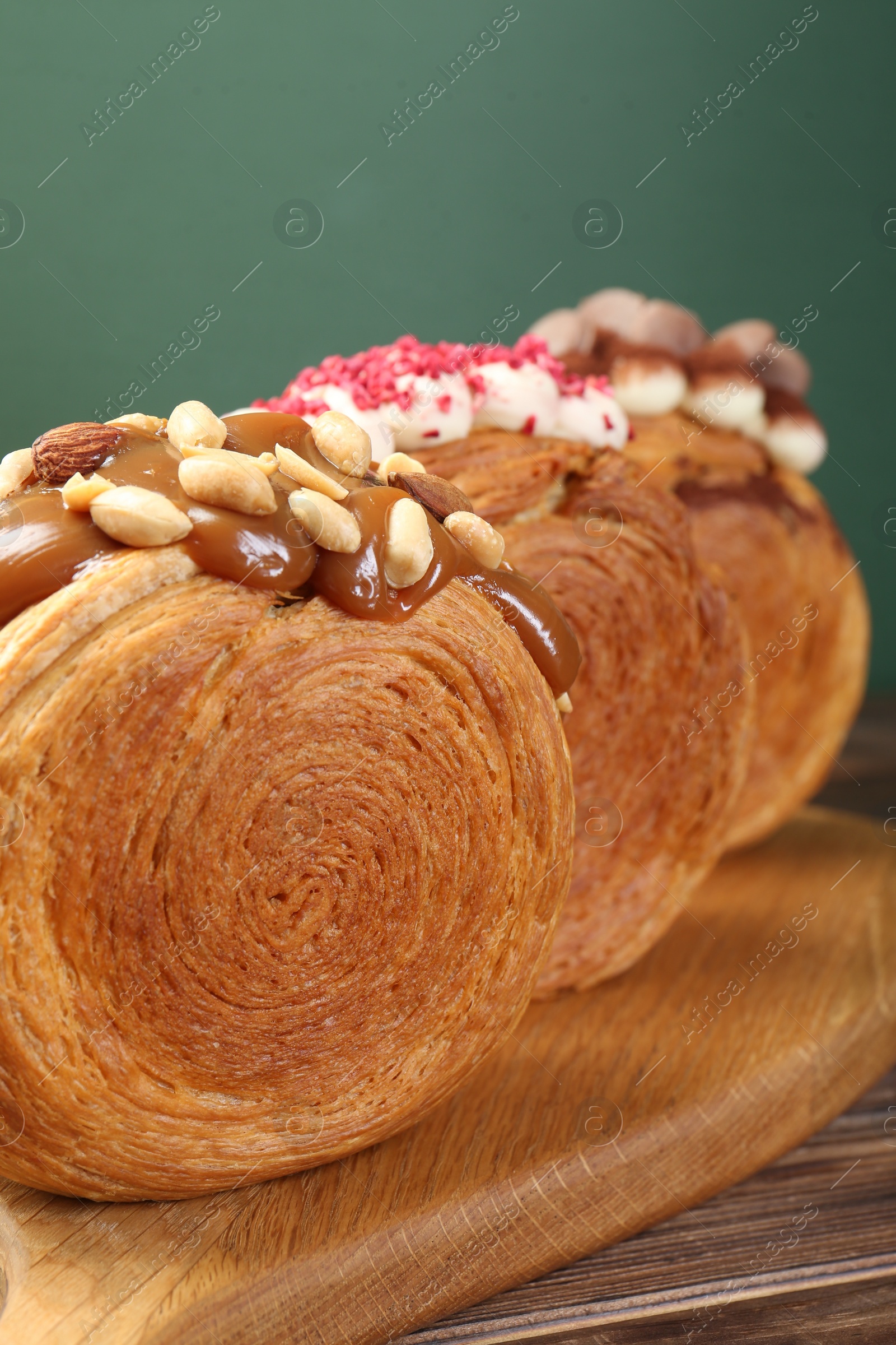 Photo of Crunchy round croissants on wooden table, closeup. Tasty puff pastry