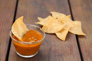 Tasty salsa sauce and Mexican nacho chips on wooden table, closeup