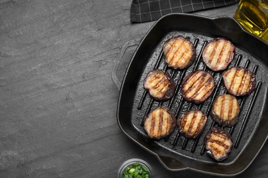 Delicious grilled eggplant slices in pan on black table, flat lay. Space for text