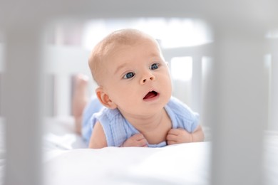 Cute little baby lying in crib at home