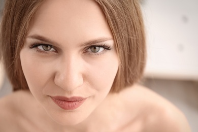 Photo of Attractive young woman with beautiful eyelashes on blurred background