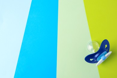 Photo of Baby pacifier on color background, top view. Space for text
