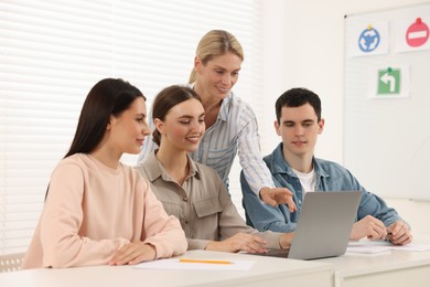 Happy teacher giving lesson in driving school