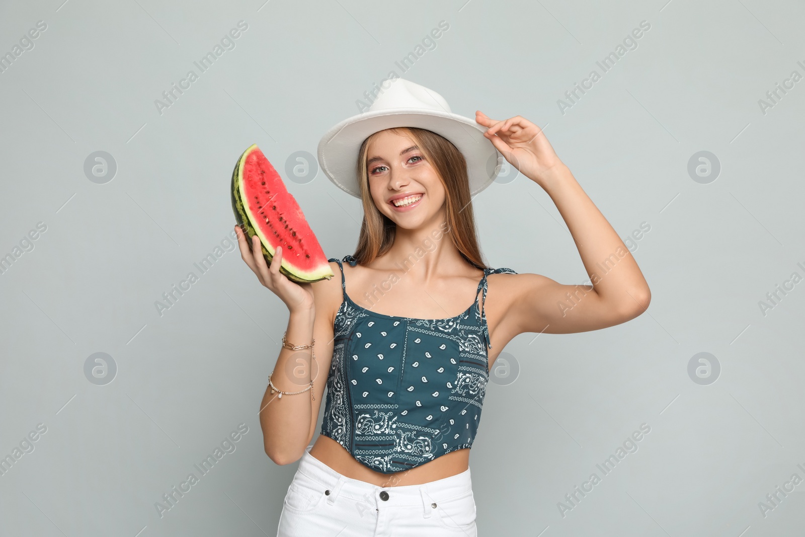 Photo of Beautiful girl with watermelon on grey background