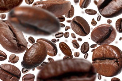 Roasted coffee beans falling o white background