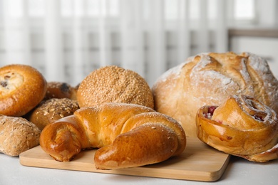 Fresh breads and pastries on white table indoors