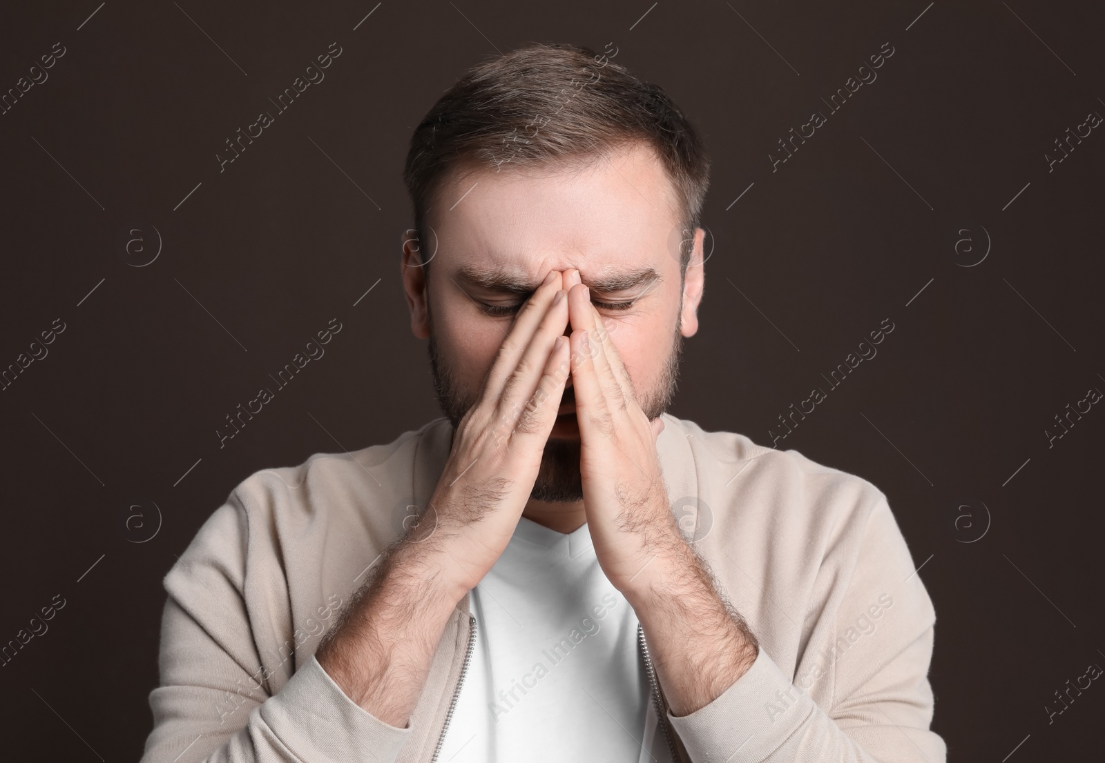 Photo of Young man suffering from headache on dark background