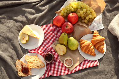 Photo of Picnic blanket with delicious food outdoors, top view