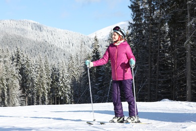 Photo of Young woman with ski equipment spending winter vacation in mountains