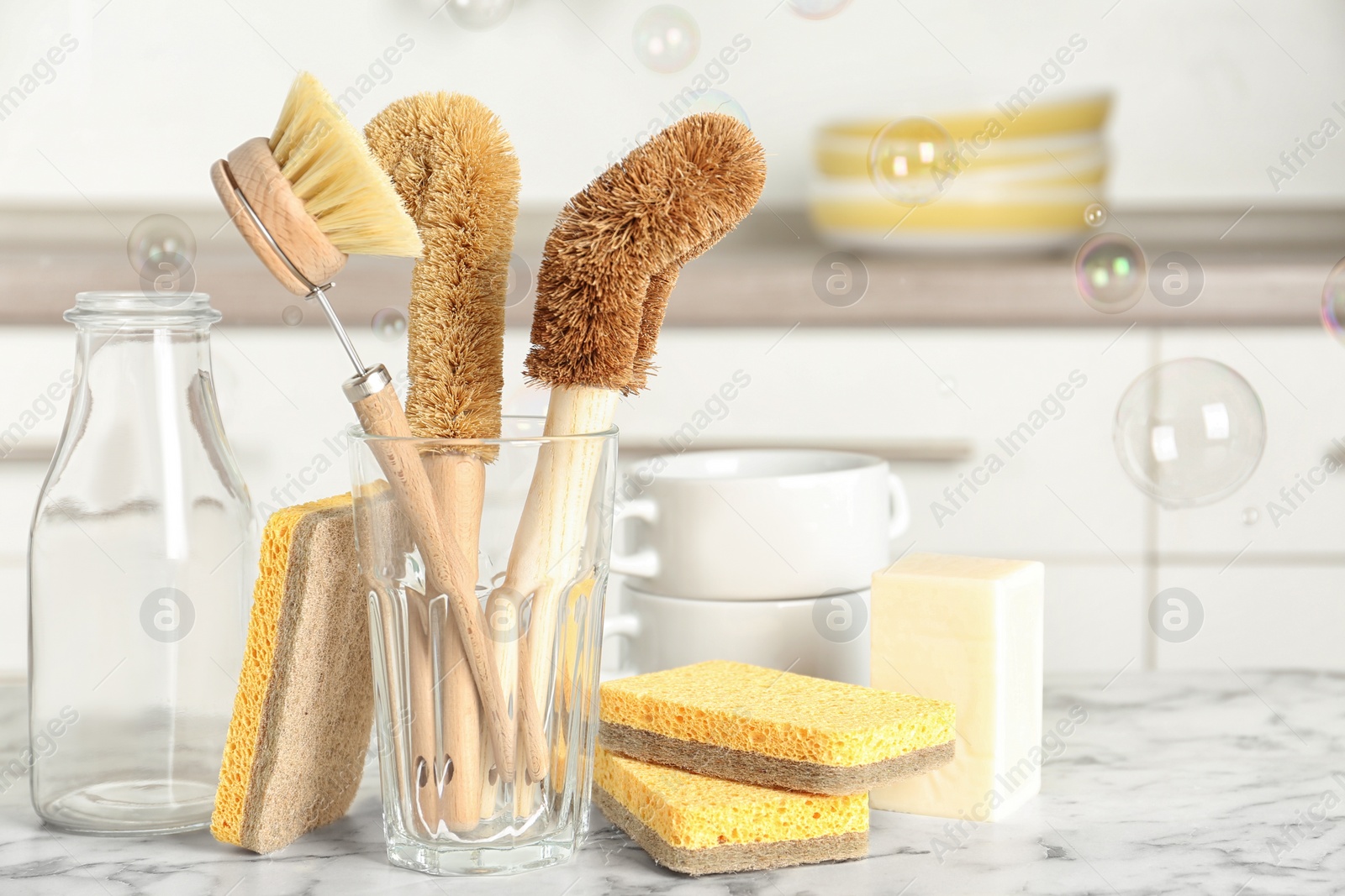 Photo of Cleaning supplies for dish washing and soap bubbles in kitchen