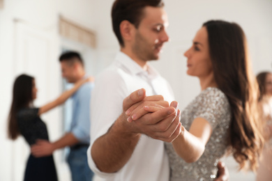 Photo of Young couple dancing at party, focus on hands