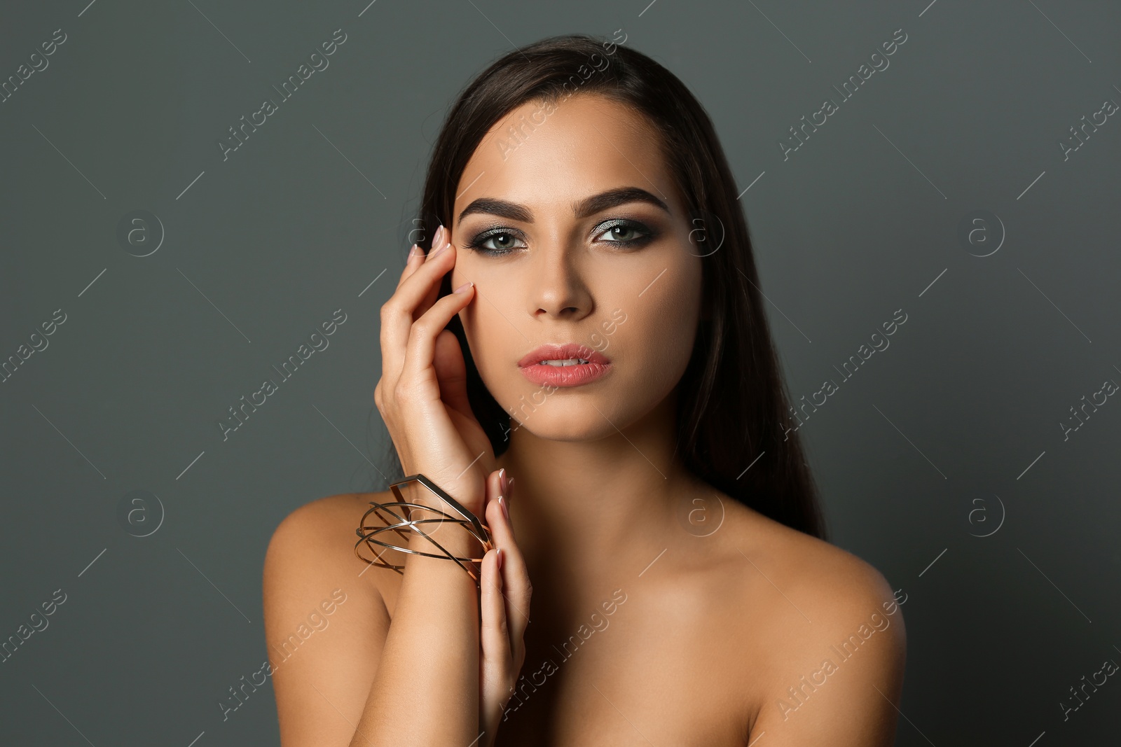 Photo of Portrait of beautiful woman with stylish makeup on gray background