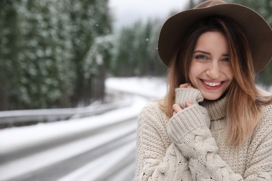 Photo of Young woman outdoors on snowy day, space for text. Winter vacation