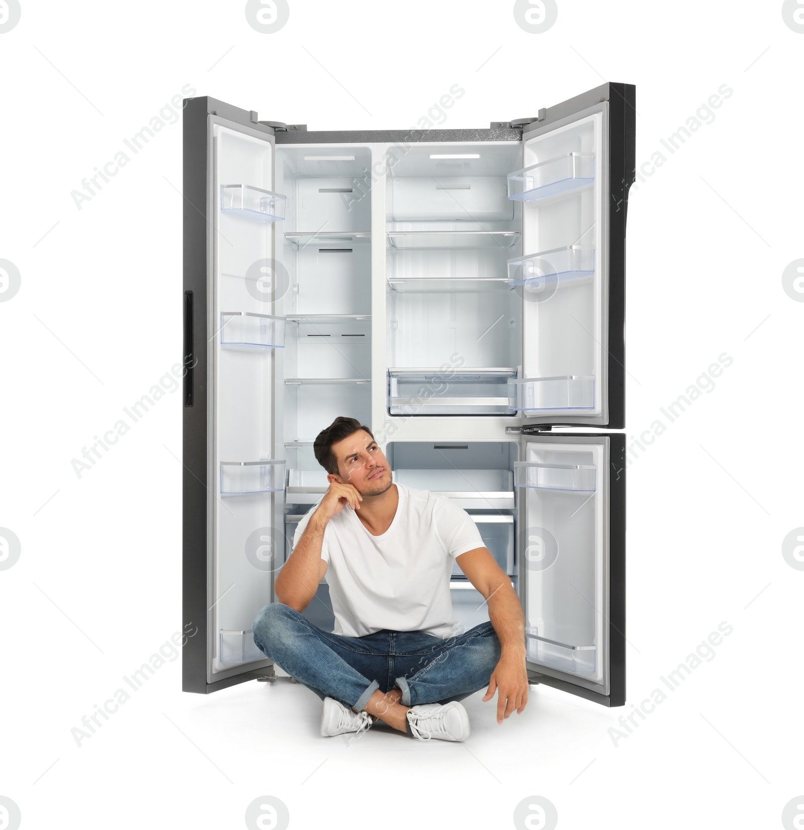 Photo of Man near open empty refrigerator on white background