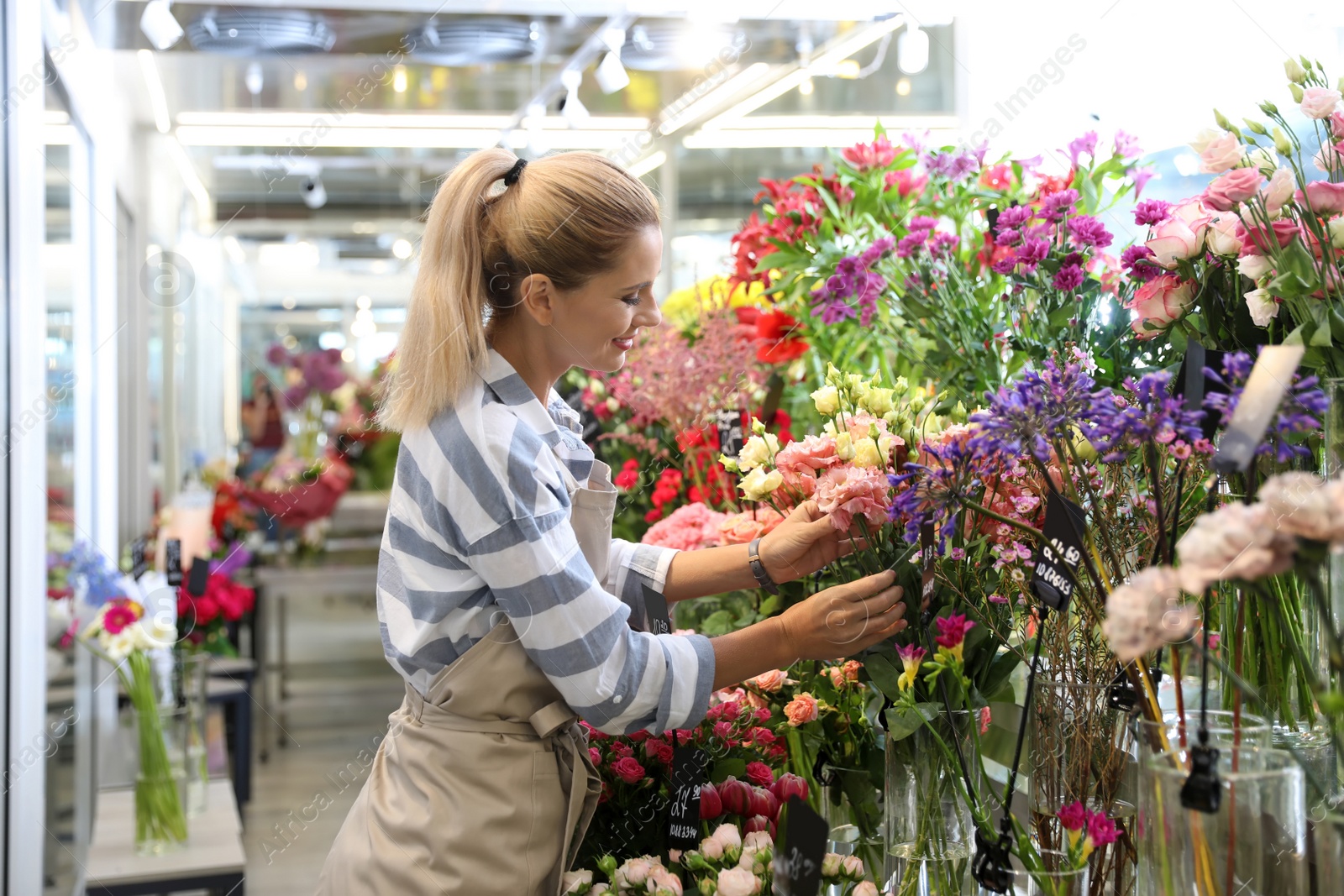 Photo of Beautiful female florist working in flower shop