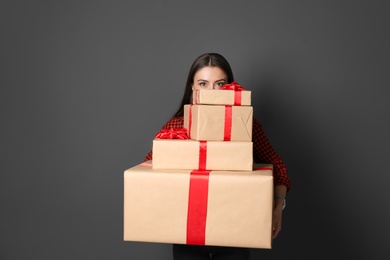 Photo of Young woman with Christmas gifts on grey background