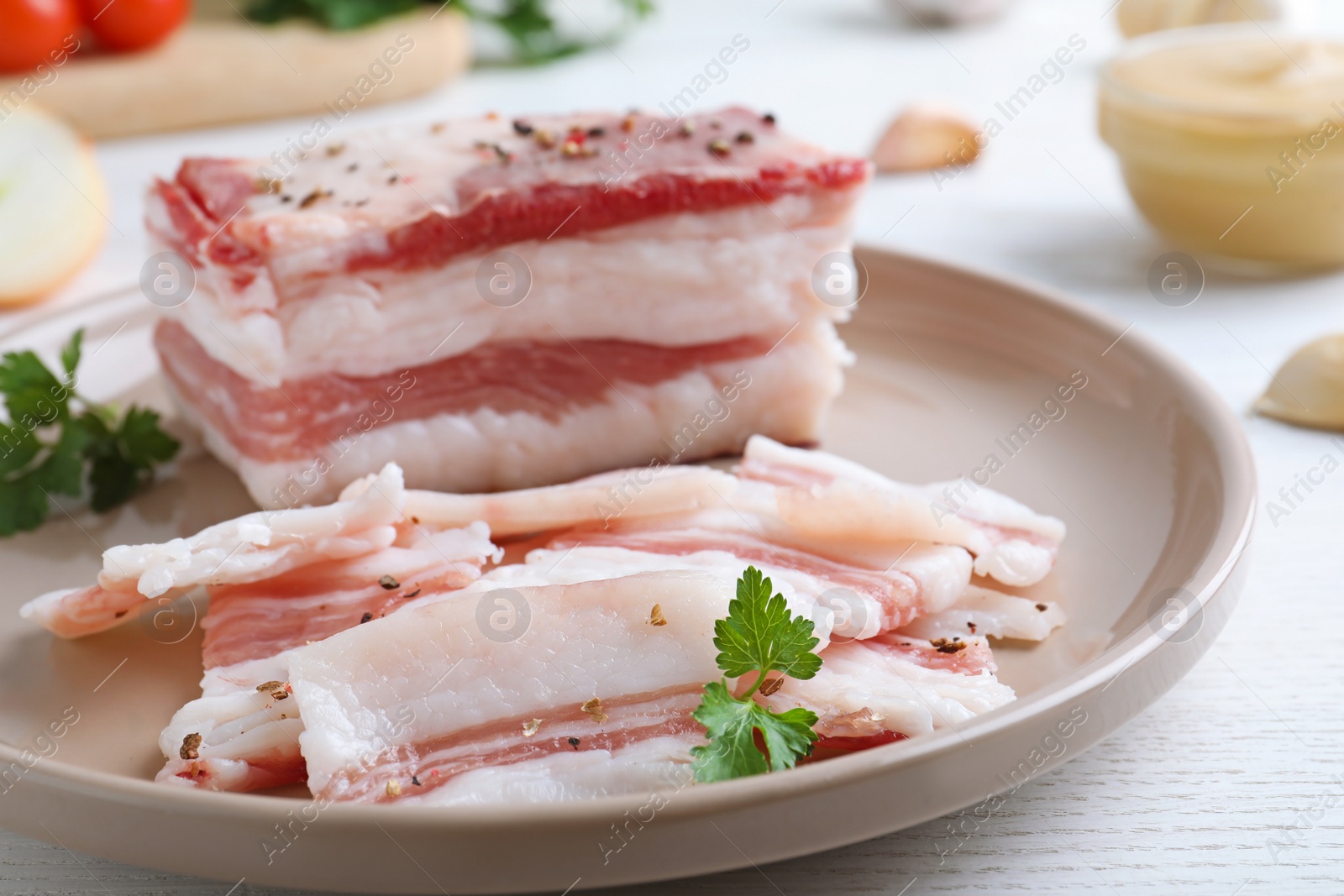 Photo of Tasty salt pork with parsley on white wooden table, closeup