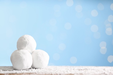 Snowballs on table against blurred lights, space for text