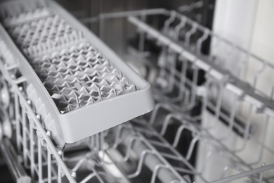 Open clean modern empty automatic dishwasher machine, closeup