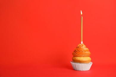 Photo of Birthday cupcake with candle on red background, space for text