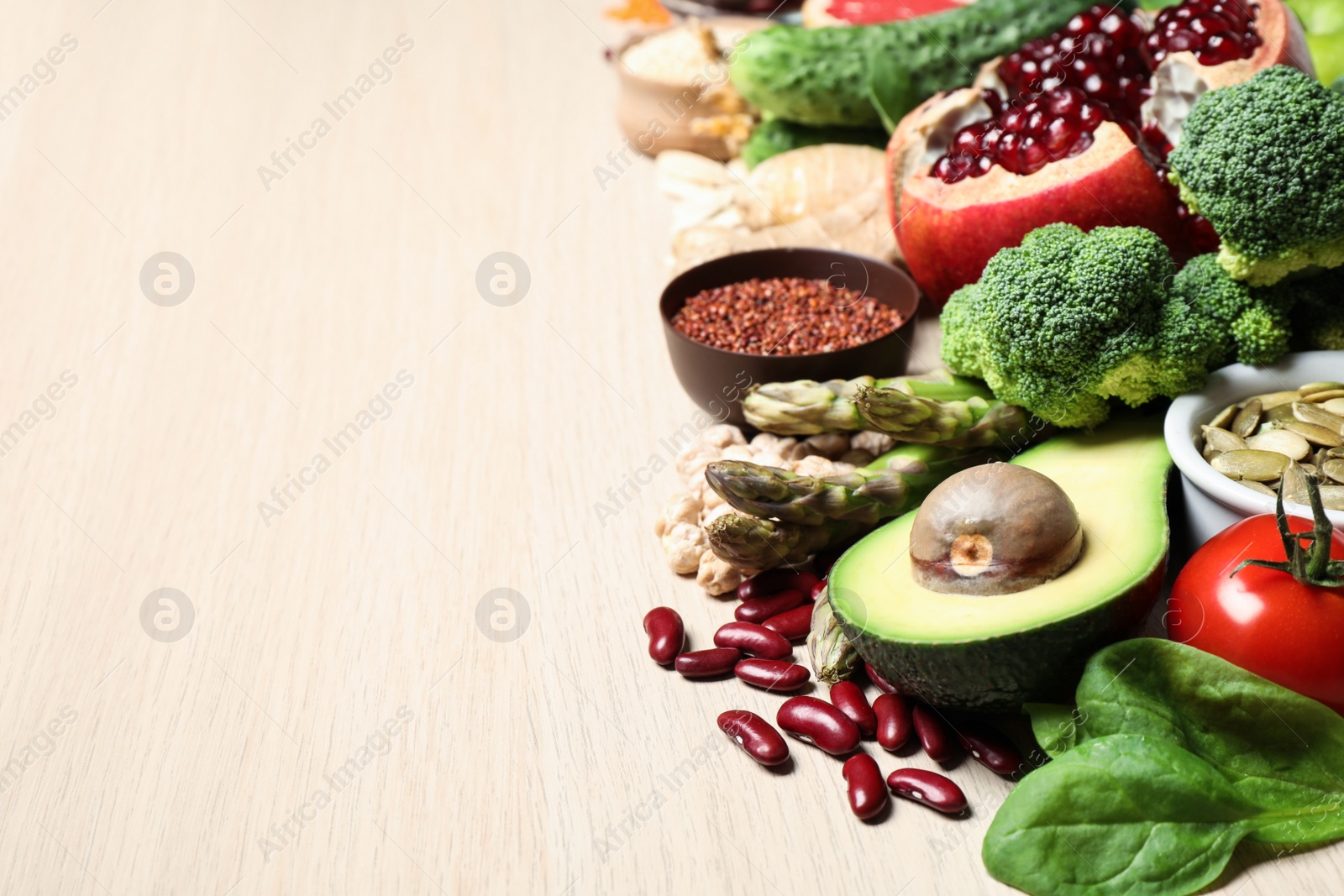 Photo of Fresh vegetables, fruits and seeds on light table, space for text