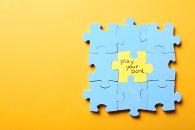 Photo of Jigsaw puzzle with phrase Play Your Part on yellow background, top view. Social responsibility concept