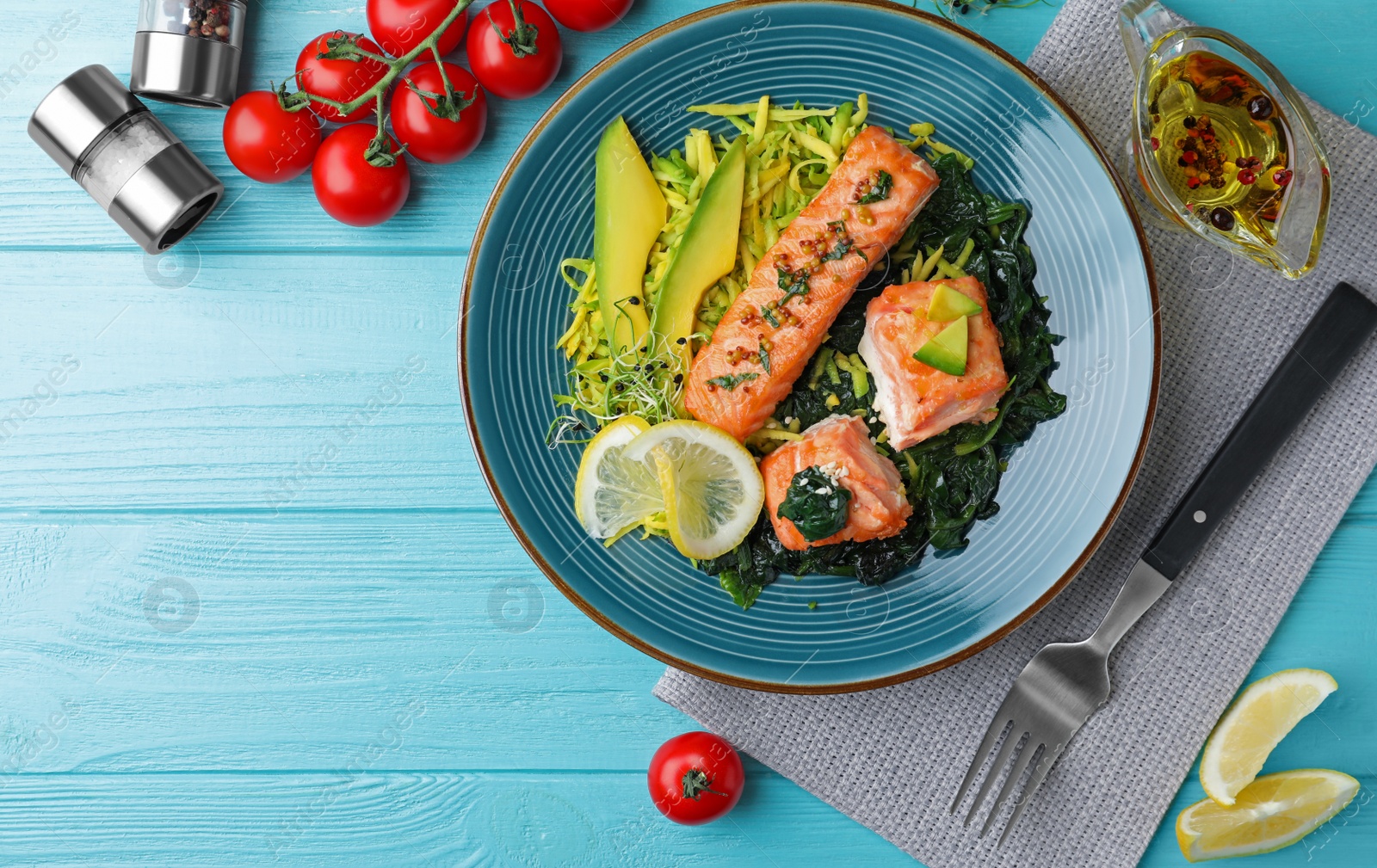 Photo of Tasty salmon with spinach served on blue wooden table, flat lay